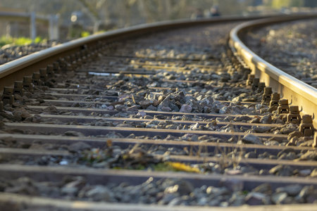 A closeup of the winding railway track filled with small rocks