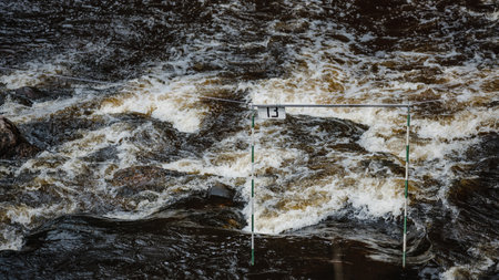 A closeup shot of the gate of whitewater slalom over the rough riverの写真素材
