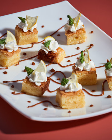 A vertical shot of sweet cake pieces with sauce served on a white plateの写真素材
