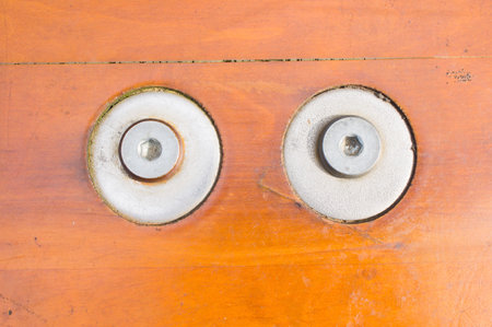 Close-up of two screws on a wooden boardの写真素材