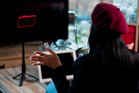 A girl video blogger or beauty blogger recording a video for subscribers in her room with a hat onの写真素材