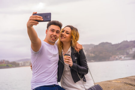 The lifestyle of a Caucasian couple sightseeing and enjoying vacations - taking a selfie on the phoneの写真素材