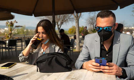 A closeup shot of a young couple sitting in a cafe outdoors