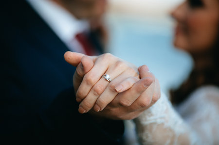 A shallow focus shot of a newly married couple holding handsの写真素材
