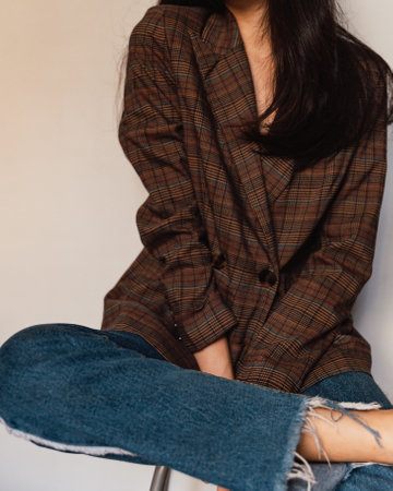 A fashionable woman wearing jeans and a stylish brown coatの写真素材