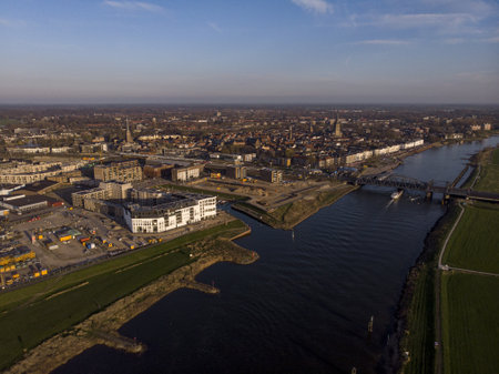 River IJssel passing by Dutch Hanseatic city of Zutphen, The Netherlands, with a steel train and traffic draw bridgeの写真素材