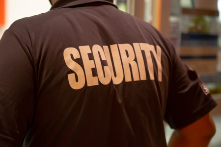 A rear view of a security guard in uniform patrolling in a commercial building.の写真素材