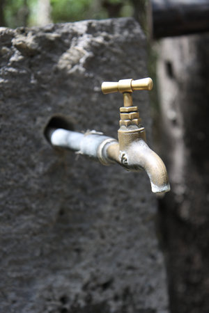 A closeup of a faucet outdoorsの写真素材