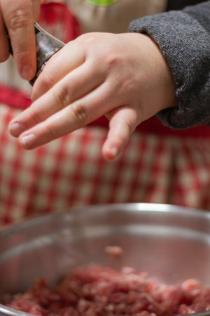 A shallow focus of a cook adding seasoning to ground meatの写真素材