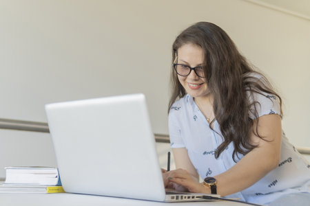 A young caucasian female working with a laptop