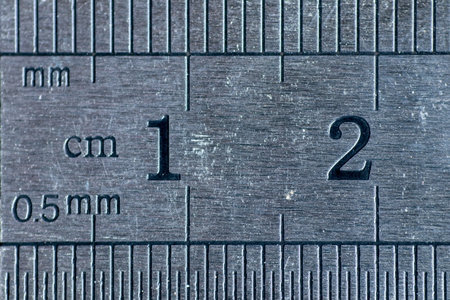 A closeup view of the numbers one and two on the old metallic rulerの写真素材