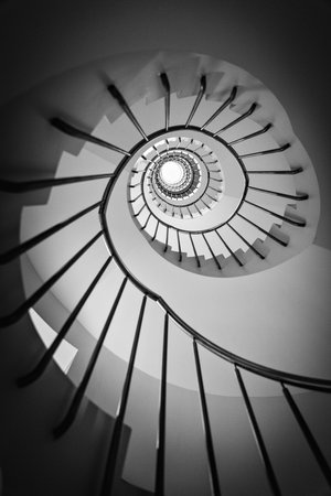 A low angle grayscale shot of the spiral staircaseの写真素材