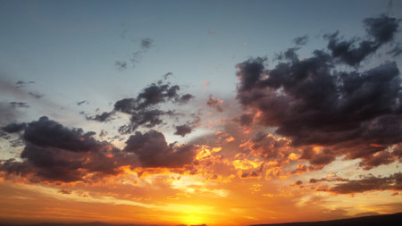 A scenic view of the beautiful sunset sky with dark clouds - great for wallpaper of desktopの写真素材