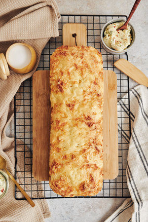 A closeup shot of delicious cheese bread with herb butter on a white table