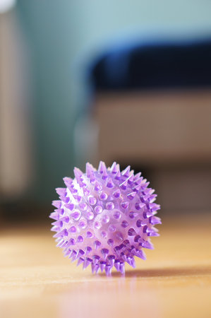 Purple toy ball with spikes on wooden floorの写真素材