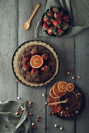 A vertical shot of a chocolate cake with dried fruits on a wooden surfaceの写真素材
