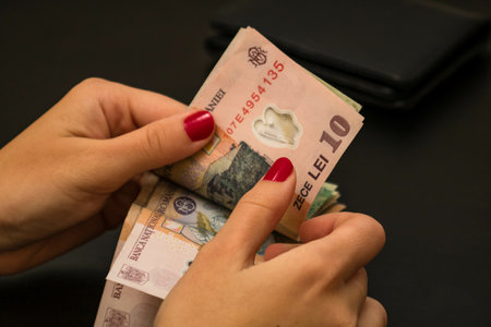 A closeup of female hands counting LEI banknotes - world money, inflation and economy conceptの写真素材