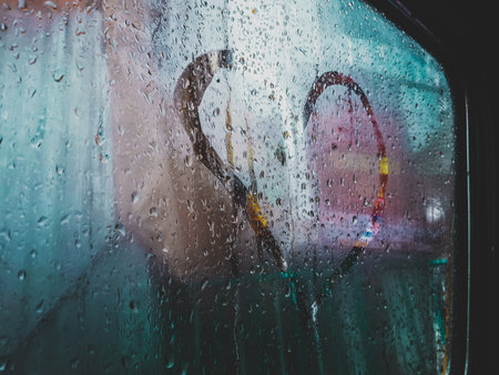A closeup shot of a heart drawn on the steamed glass with raindrops