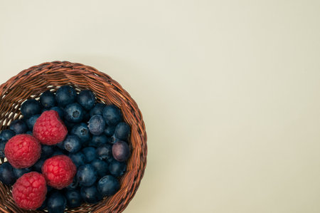 A top view of blueberries and raspberries in a basket