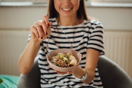 A shot of a girl holding plate bowl with a tasty smoothie made with banana and kiwi.の写真素材