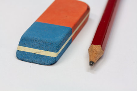 A closeup shot of rubber and a red pencil on a white backgroundの写真素材