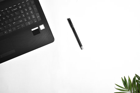 A top view of a black laptop with pen isolated on white with a copy spaceの写真素材