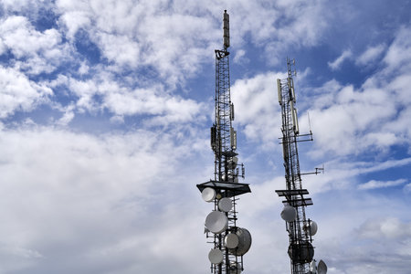 A telecommunications towers against cloudy sky backgroundの写真素材