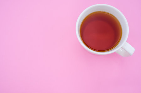 A top view of a white cup of tea isolated on pink backgroundの写真素材
