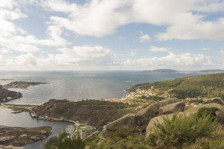 A landscape of hills covered in greenery surrounded by the sea in Ezaro, Spainの写真素材