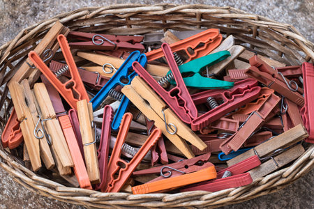 A top view of colorful plastic and w clothespins in a basketの写真素材