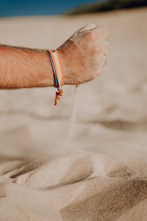 A vertical shot of a person playing with the sand at the beachの写真素材