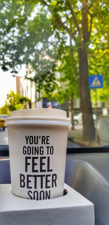 A closeup shot of disposable paper coffee cup with an inspirational quote to strengthen mental healthの写真素材