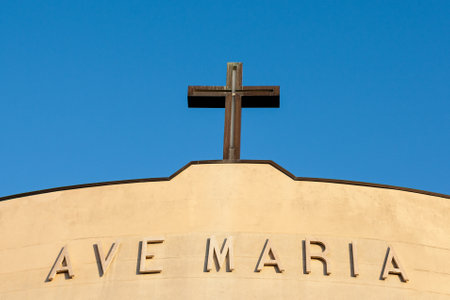 A shot of a Christian cross on the top of church roof, written AVE MARIAの写真素材
