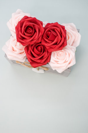A vertical shot of beautiful red and white roses in a box isolated on a grey backgroundの写真素材
