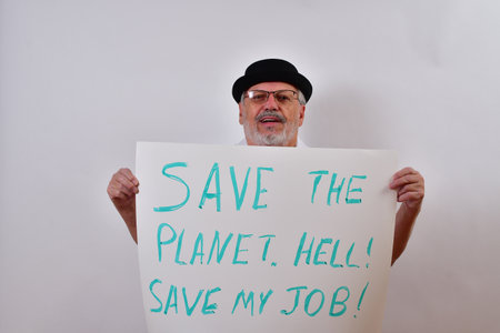 A view of an elderly man holding a sign for saving the planet on a white backgroundの写真素材