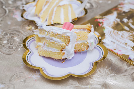 A top view of pieces of a birthday cake on plates isolated on a beige tableclothの写真素材