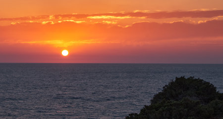 A beautiful orange sunset at Roche Cove in Conil de la Frontera, Spainの写真素材