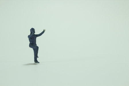A minifigure of a person standing on one leg with raised arms /miniature peopleの写真素材