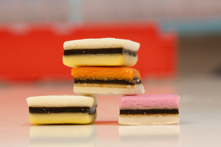 A closeup shot of colourful yummy liquorice candies on a red blurred backgroundの写真素材