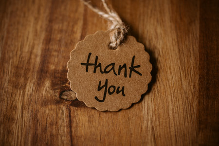 Thank you word written in a card on wooden background with selective focus. Love and gratitude concept.の写真素材