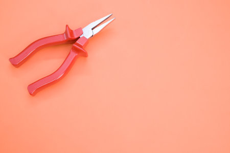 A closeup shot of long nose pliers on a colorful backgroundの写真素材