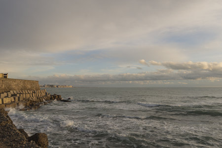 A coastal area with rocks on background of the wavy sea in Cadiz, Andalucia, Spain