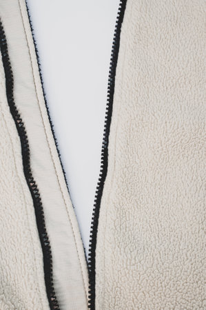 A closeup shot of a black zipper of a white soft jacketの写真素材