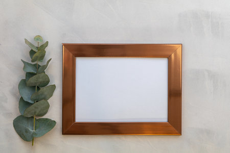 A top view of the golden photo frame with eucalyptus branchの写真素材