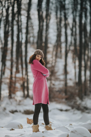 A young Bosnian woman posing in the forest in the winterの写真素材