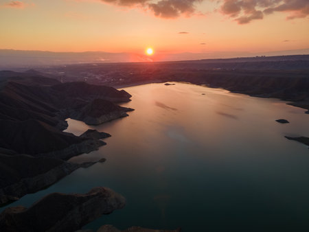 An aerial view of a vast landscape and a lake during a beautiful sunsetの写真素材
