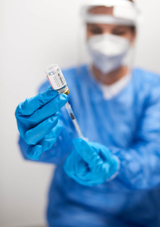 A doctor filling a syringe with COVID-19 vaccine from an ampuleの写真素材