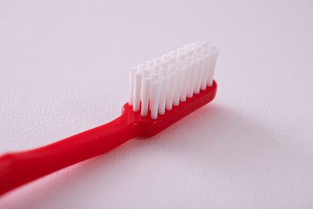 A close up shot of a red toothbrush isolated on white backgroundの写真素材
