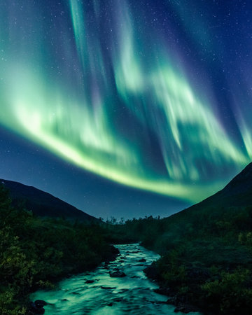 A vertical shot of a nightspring landscape with Northern lights reflection on the riverの写真素材