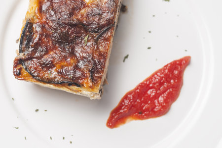 An eggplant pie with ham, cheese, tomatoes, and eggsの写真素材